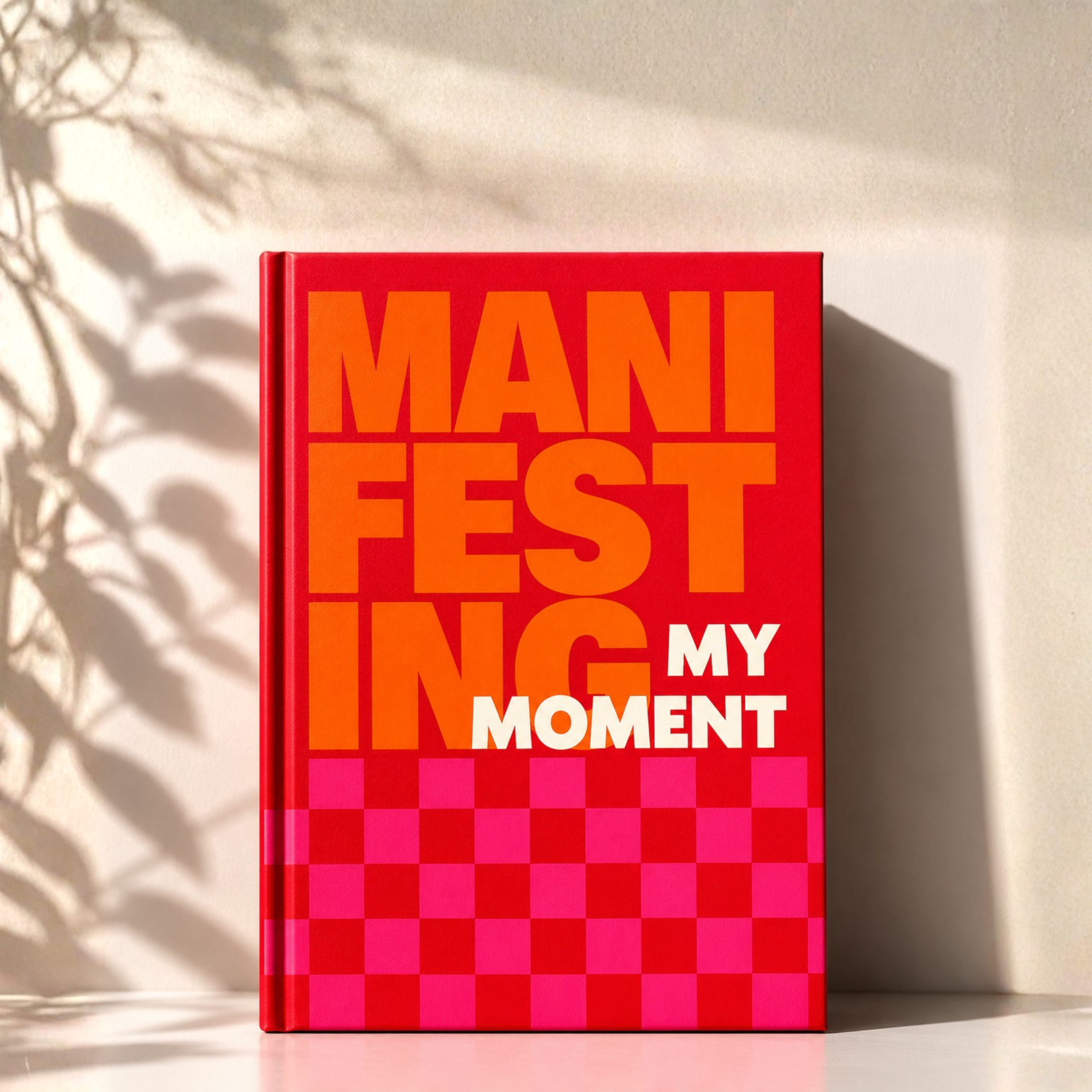 'Manifest My Moment' Planner Cover with a red and pink checkered design on a light background